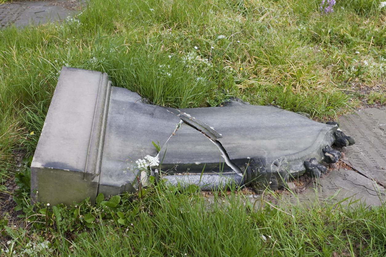 "Old gravestone in churchyard cemetry, fallen over and smashed in half. Location is Knutsford, Cheshire, UK."